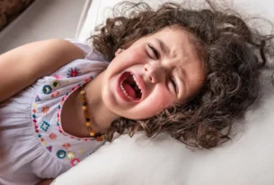 Mãe acolhendo criança em momento de birra com paciência.